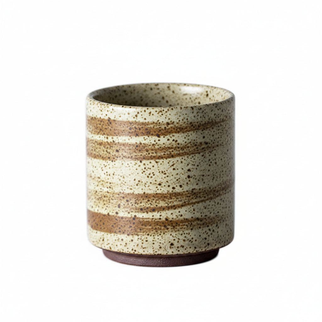 Rough pottery tea cup with retro colour glaze, earthy tones on white background